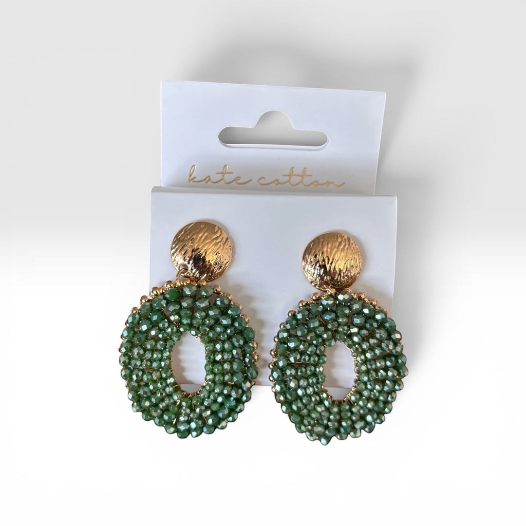 Home-Industry South Africa Halo Sage beaded statement earrings with green crystals and textured gold studs on display.