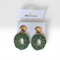 Home-Industry South Africa Halo Sage beaded statement earrings with green crystals and textured gold studs on display.