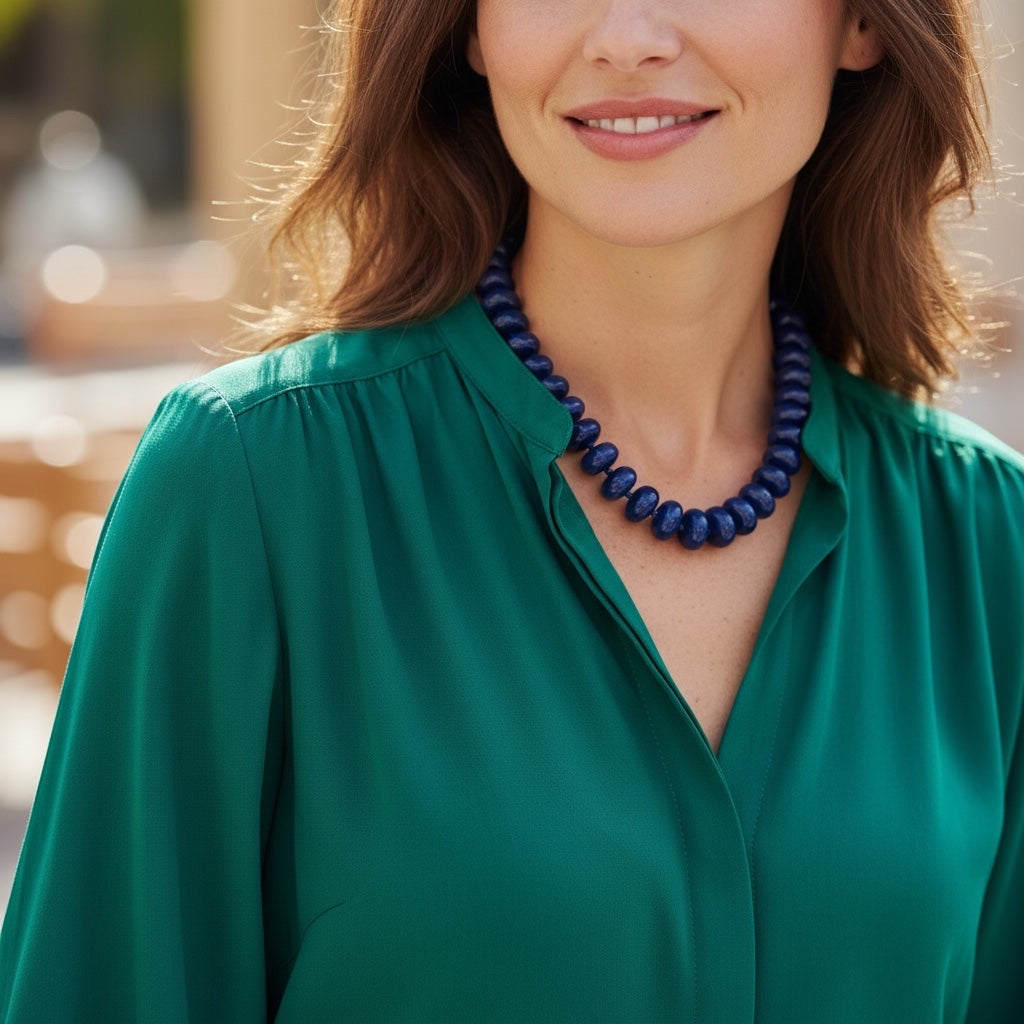 Home-Industry South Africa midnight blue glossy resin bead necklace on a woman wearing a green blouse.