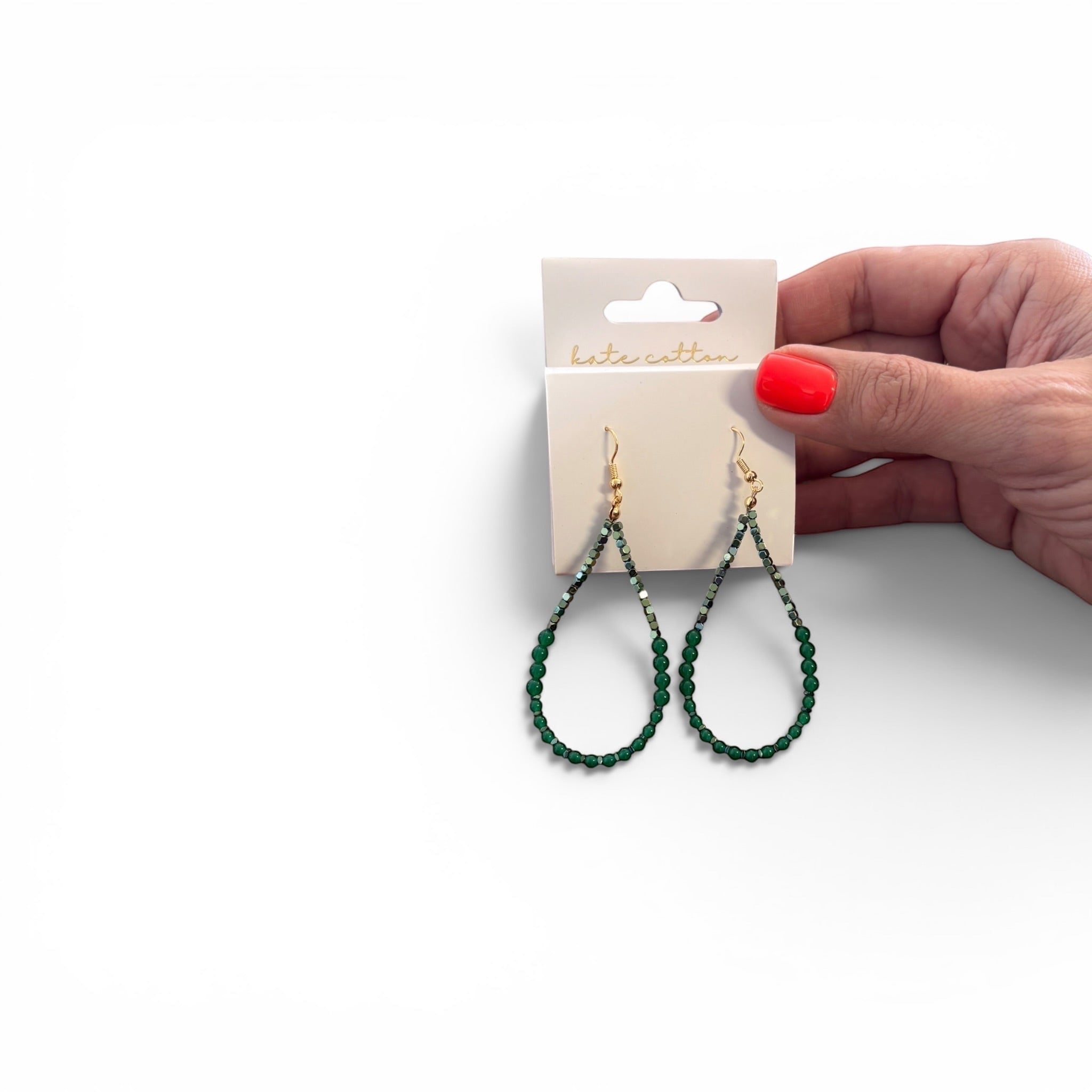 Home-Industry South Africa Willow green beaded teardrop earrings with gold-tone hooks held against a white background.